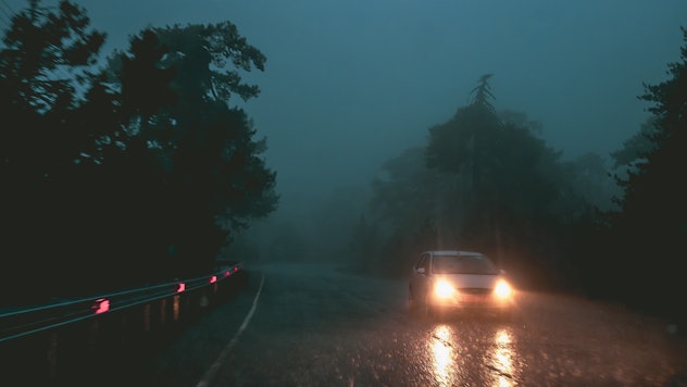 Car in the dark foggy road