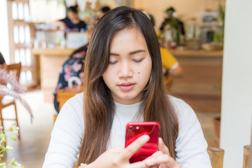 Busines casual women texting on smartphone sitting in cafe