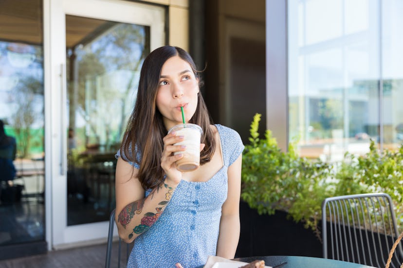 Thoughtful young woman drinking coffee at cafe