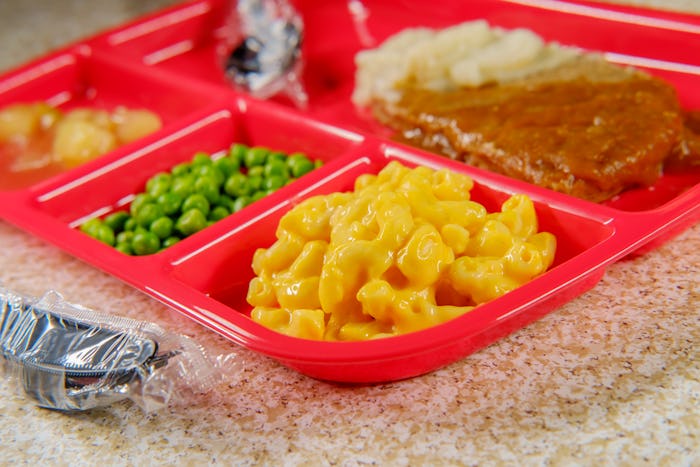 Grade school lunch salisbury steak on tray with peas macaroni and cheese and apple sauce