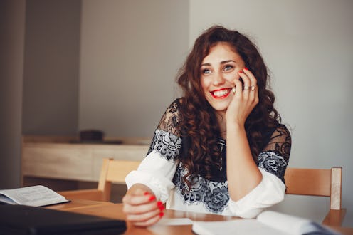 Beautiful girl in the office. Woman is working. A woman with curly hair