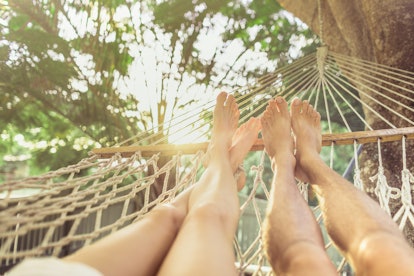 Young couple relaxing in hammock enjoying summer holiday vacation