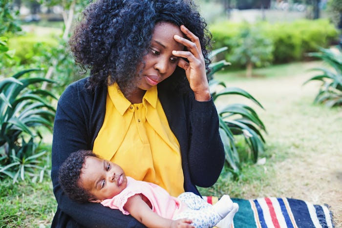 Sad african woman holding her child and thinking