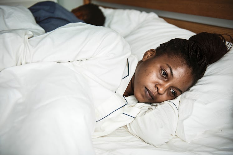 A woman wide awake in bed