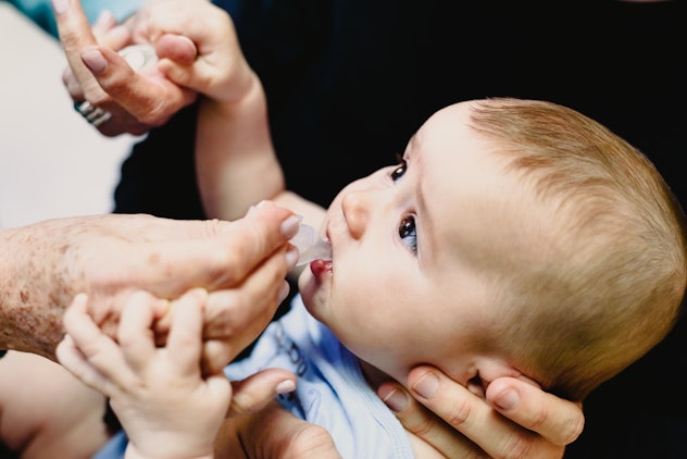 Baby vaccinated with a drinkable ampule provided by a pediatrician.