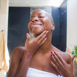 lifestyle natural portrait of young attractive and happy black afro American woman at home bathroom ...