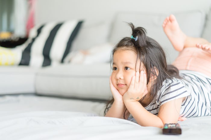 Little asian cute girl watching tv on her sofa alone.