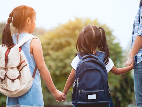 Back to school. Asian mother and daughter pupil girl with backpack holding hand and going to school ...