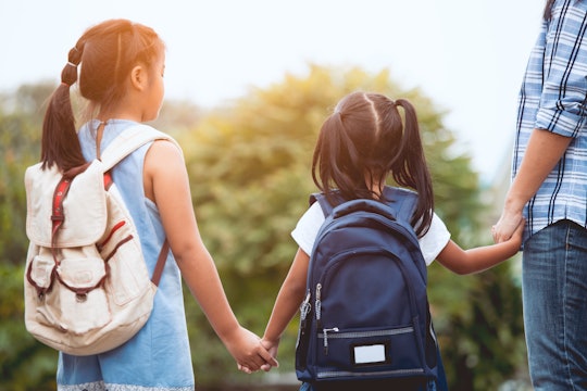 Back to school. Asian mother and daughter pupil girl with backpack holding hand and going to school ...