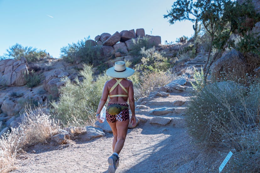 Woman Hiking Up Pinnacle Peak Desert Trail In Scottsdale, Arizona in summer time. 