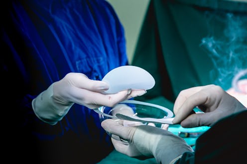 surgeons unpacking breast implant for placement. Breast Augmentation Surgery