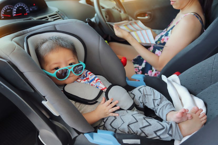 mother and son drive road trip family travel in summer vacation day, cute baby boy sitting on car se...