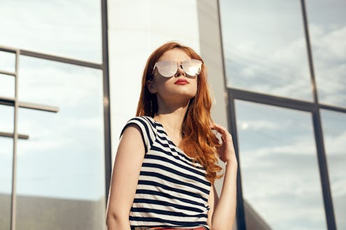 Woman in glasses, woman background, woman on mirror building background.