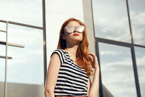 Woman in glasses, woman background, woman on mirror building background.