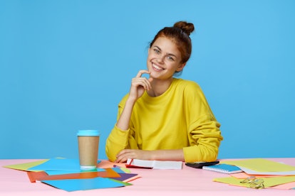 jobs woman sitting at the table on a blue background and a cup of coffee stationery                 ...