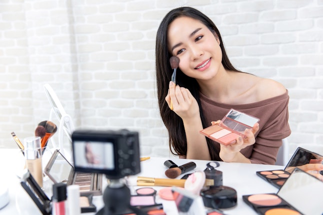 Young beautiful asian woman beauty professional vlogger or blogger recording makeup tutorial to share on social media