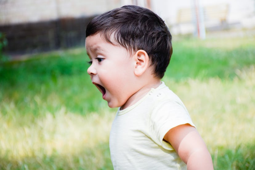 Little latin boy shouting outdoors.