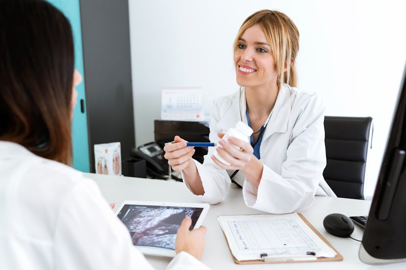 Shot of pretty young woman gynecologist doctor prescribing medication for pregnant in the medical co...