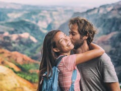 Couple in love kissing on nature travel hiking in Hawaii mountains. Young hikers people happy togeth...