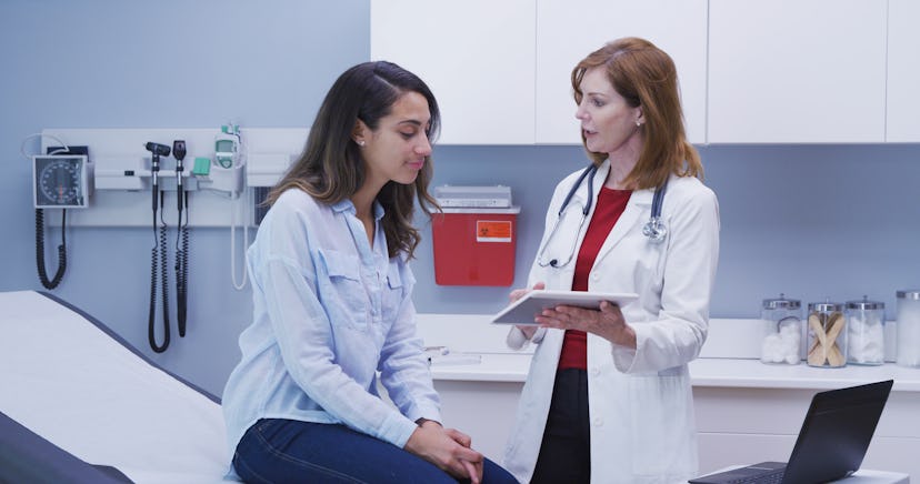 Lovely young latina patient consulting with doctor about health condition