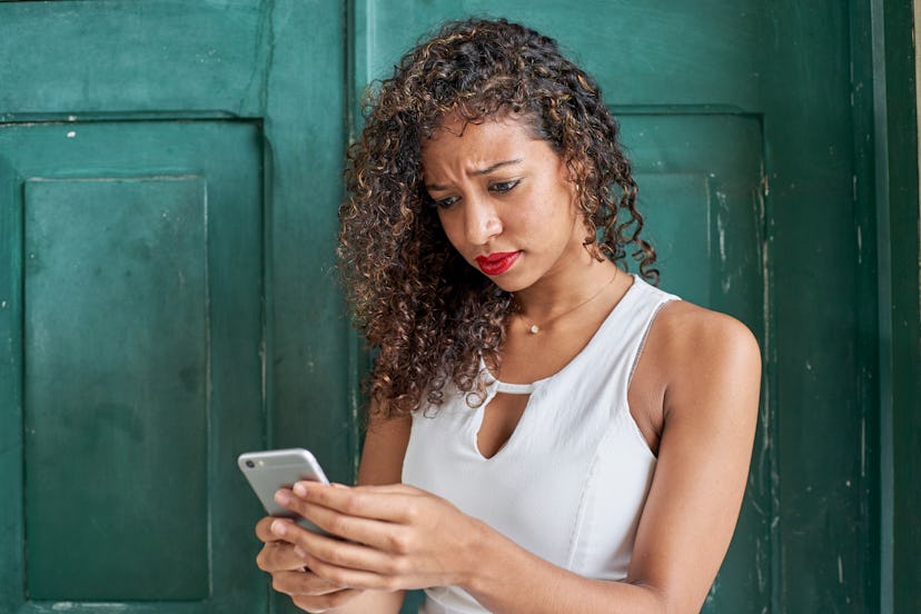 Woman with annoyed face checking the phone.