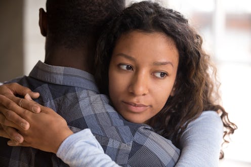 Pensive young mixed race girlfriend think of something hugging boyfriend making peace after fight, w...