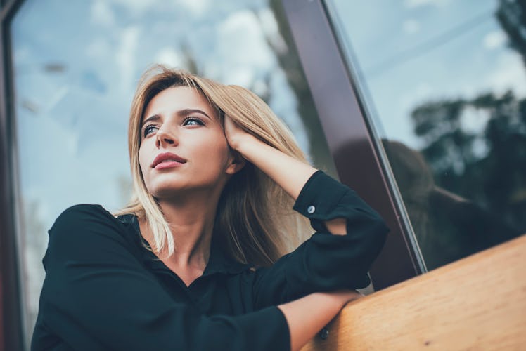 Below view of pondering woman dressed in stylish black shirt thougthful looking away and thinking on...