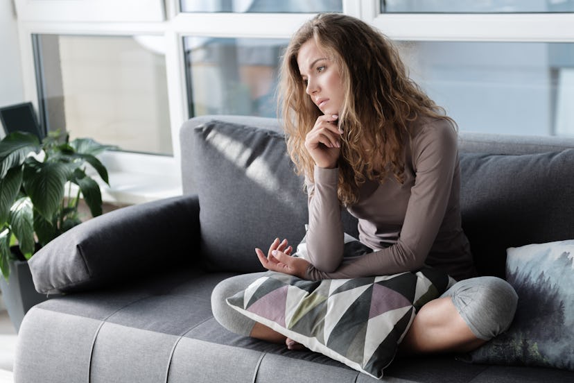 Sad woman locating on comfortable couch