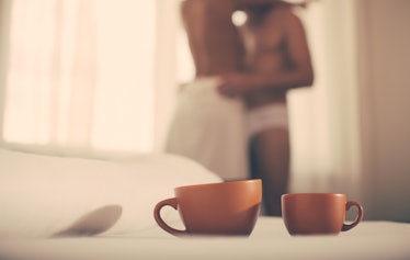 Luxury bedroom with cup of coffee. Two cups of coffee in morning. Passionate couple kissing, boy and...