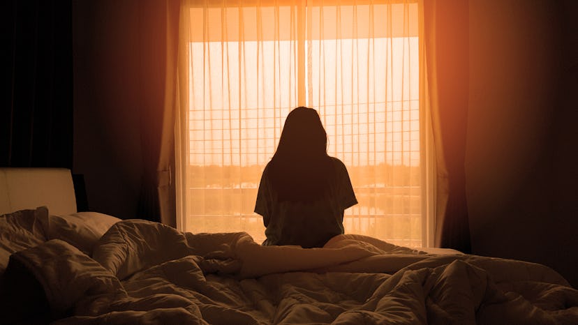 sadness woman sitting on the bed in the morning with sunlight from the windows