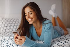 Young woman texting from the bed
