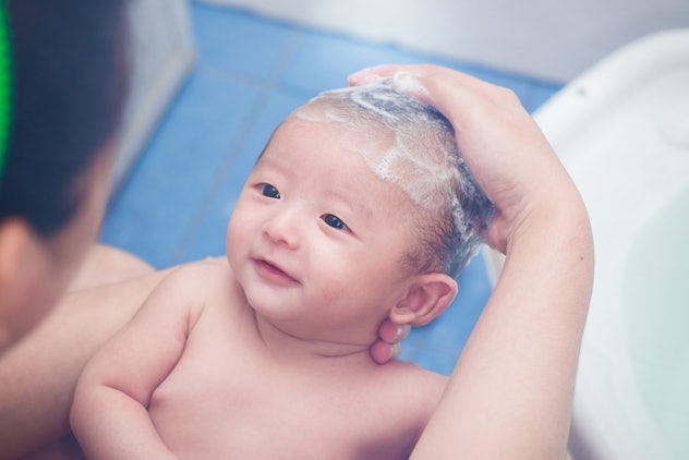 Mother give a bath her newborn baby in bathroom, focus at the eye, soft tone