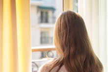 little girl on a Sunny morning looking out the window