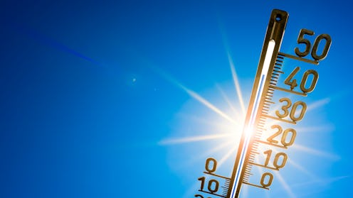 Hot summer or heat wave background, bright sun on blue sky with thermometer