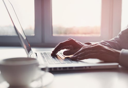 Business man using laptop computer. Male hand typing on laptop keyboard