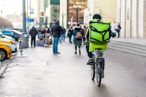 courier on bike deliever tasty food in city streets