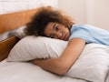 Worried girl hugging pillow and having depressing thoughts, lying in bed
