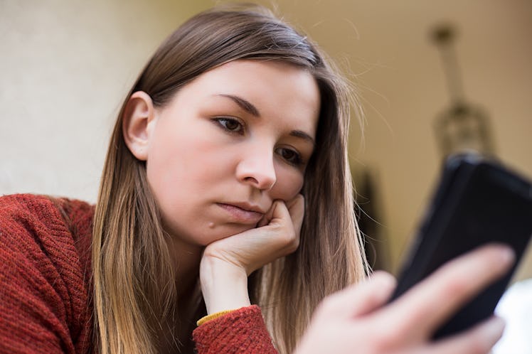 Young girl with smart-phone whatching bad news in internet