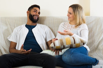 Young interracial couple talking in domestic interior