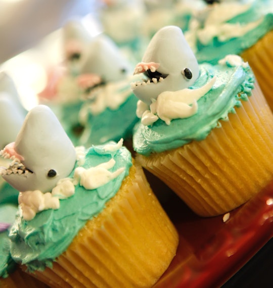Unique cupcakes with sharks and green frosting with white.