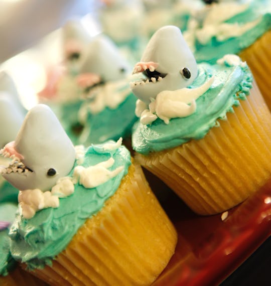 Unique cupcakes with sharks and green frosting with white.