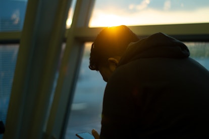 Sad guy waiting at the airport with sun glare