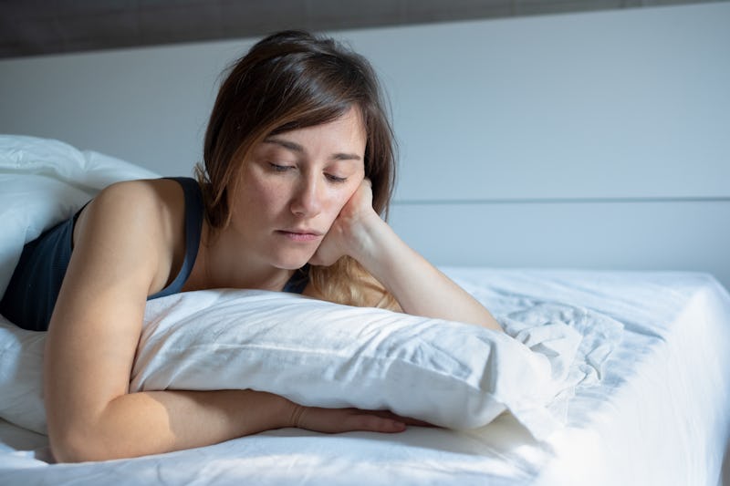 Sad woman can't sleep lying in her bed at home