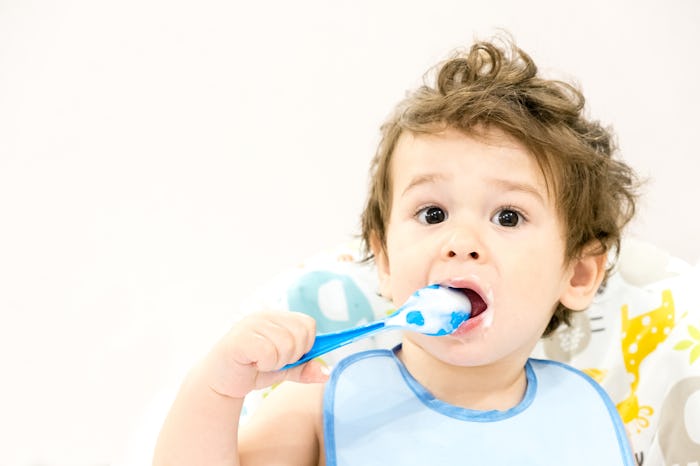 Portrait of a baby eating with a stained face.
