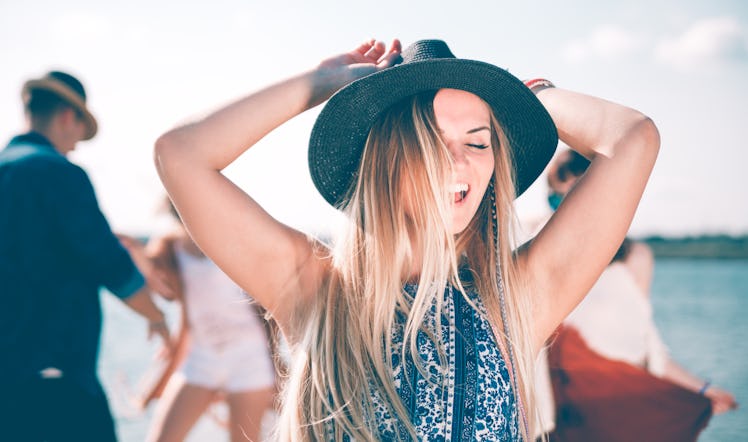 Group of friends dancing and celebrating on beach, boho party outdoor