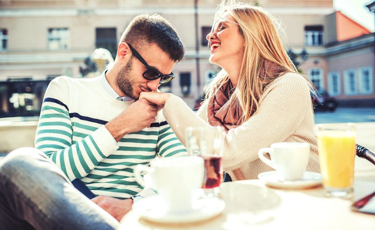 Flirting in a cafe. Beautiful loving couple sitting in a cafe enjoying in coffee and conversation. L...