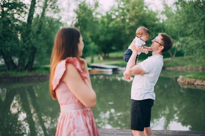 family with a small child on the lake. mom and dad walk in nature with his son
