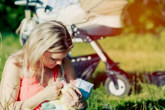 Girl is breastfeeding in nature. Copy space