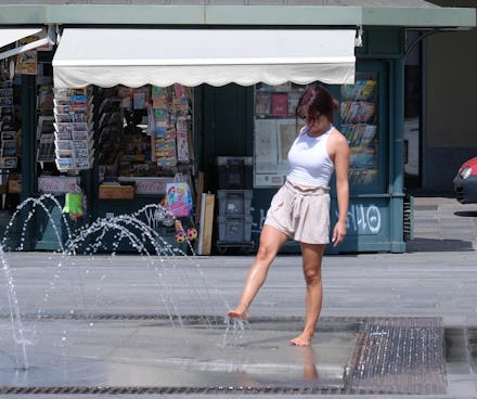 A woman cools off at a fountain in downtown Turin, Italy, 27 June 2019. Temperatures registered 34 d...