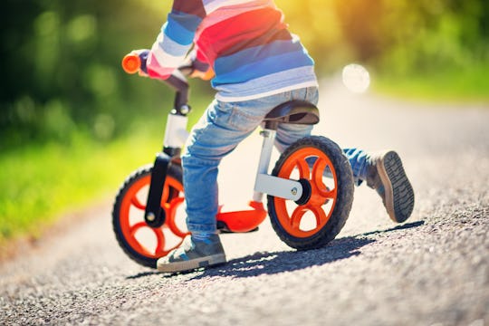 children riding on a bicycles at gravel road in the park in summer